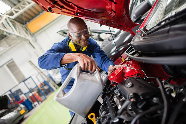 Mechanic changing oil on a car at the garage